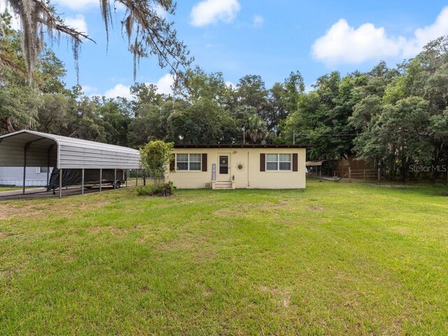 back of property featuring a lawn and a carport