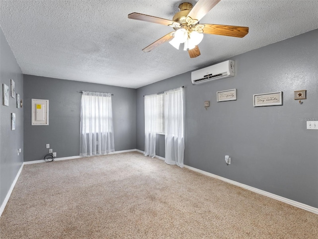 carpeted spare room with ceiling fan, a wall mounted air conditioner, and a textured ceiling