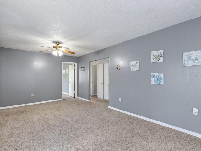 carpeted empty room with ceiling fan and a textured ceiling