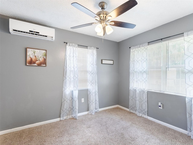 unfurnished room with a healthy amount of sunlight, a textured ceiling, light carpet, and an AC wall unit