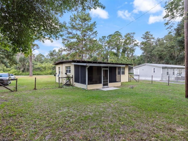 back of property featuring a yard and a sunroom