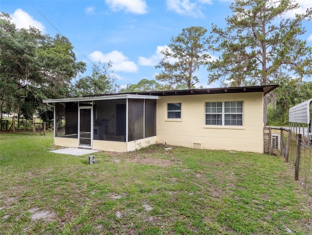 rear view of property featuring a yard and a sunroom