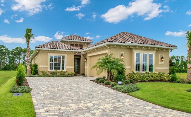 mediterranean / spanish home with a garage and a front yard