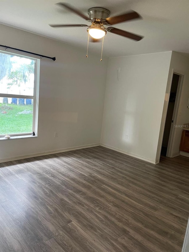 spare room featuring ceiling fan and dark wood-type flooring