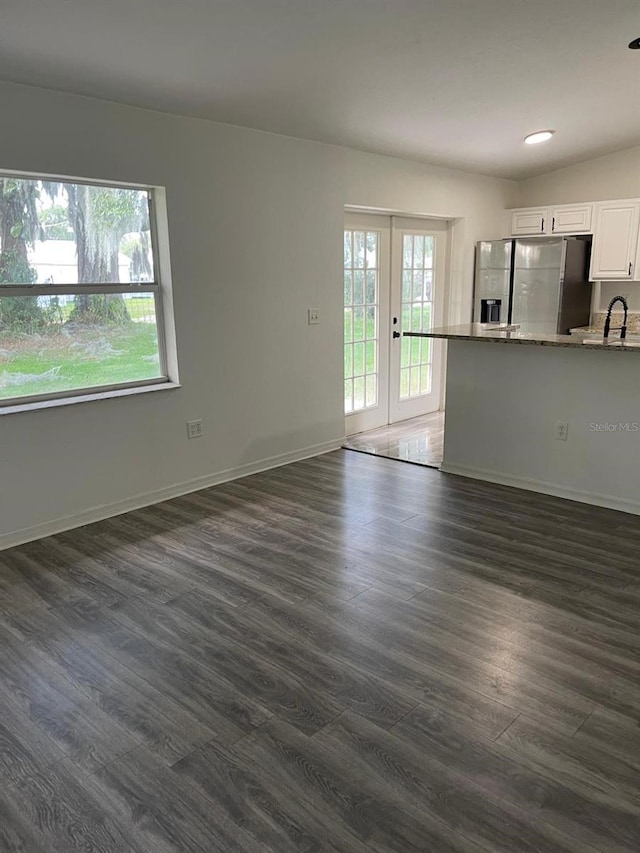 unfurnished living room featuring dark hardwood / wood-style floors, sink, and french doors