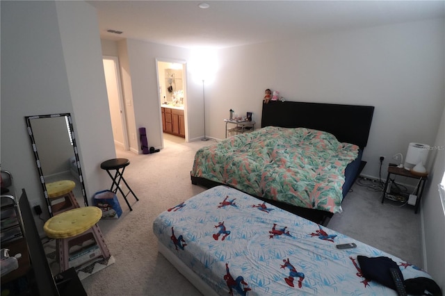 bedroom featuring light colored carpet and connected bathroom