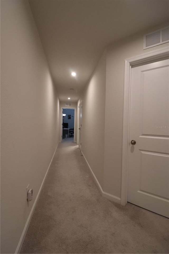 corridor featuring light colored carpet