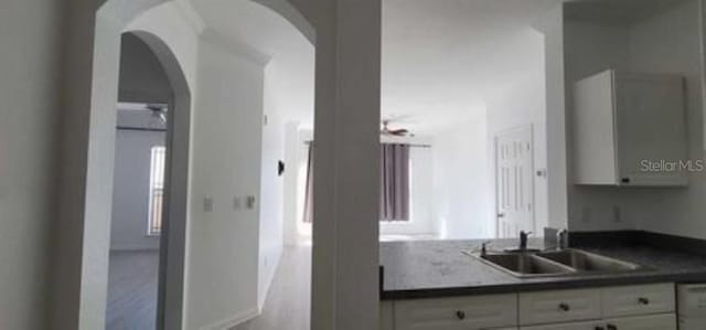 kitchen with light hardwood / wood-style floors, white cabinets, and sink