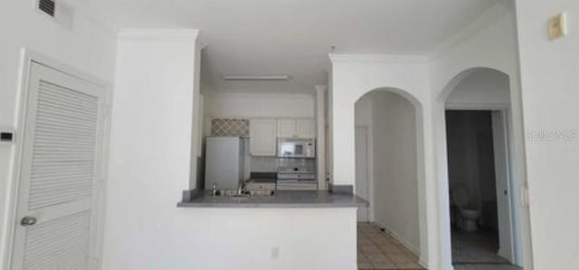 kitchen featuring light tile flooring and white appliances