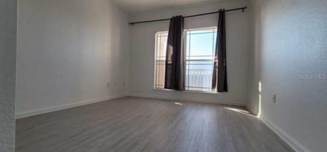 spare room featuring a barn door and hardwood / wood-style floors