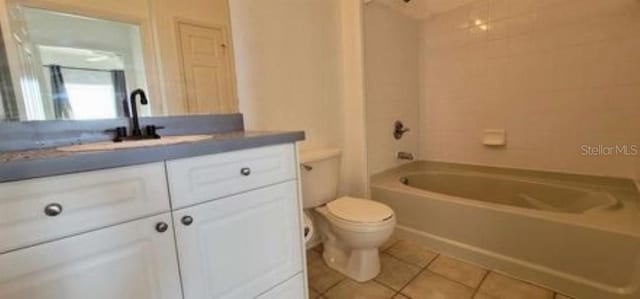 full bathroom featuring toilet, tile flooring, tiled shower / bath combo, and vanity