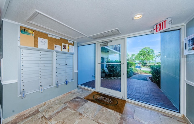 interior space featuring mail boxes, a textured ceiling, and tile floors