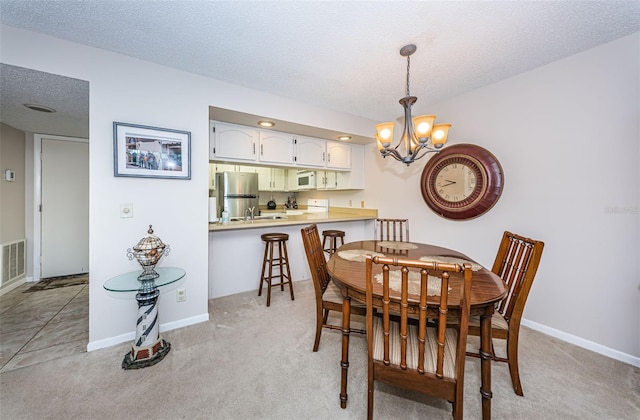 carpeted dining area with an inviting chandelier, a textured ceiling, and sink