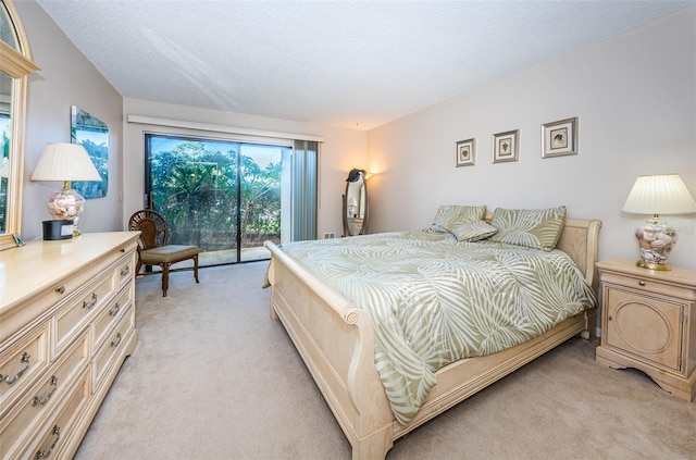 bedroom with light carpet, a textured ceiling, and access to outside