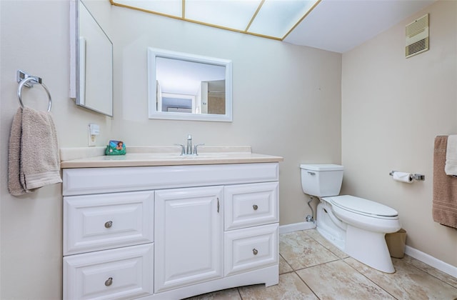 bathroom with toilet, vanity, and tile flooring