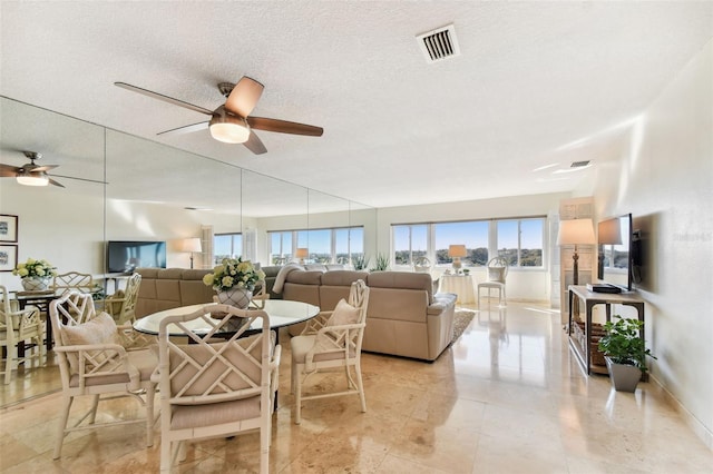 dining space with a textured ceiling and ceiling fan