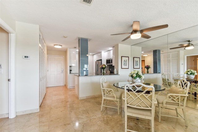 dining space featuring a textured ceiling and ceiling fan