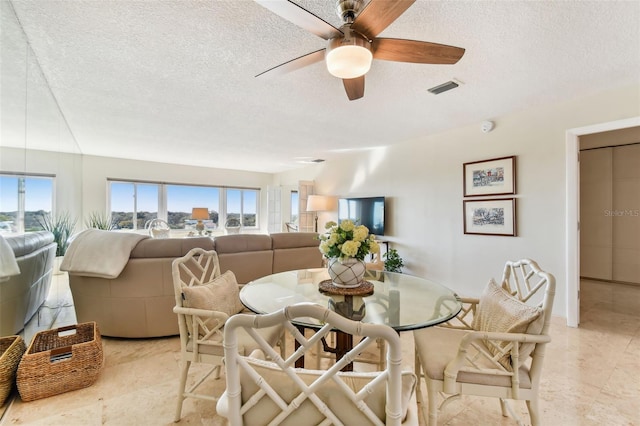 dining room featuring ceiling fan and a textured ceiling