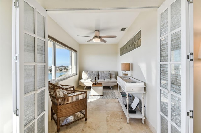 interior space featuring ceiling fan and a water view