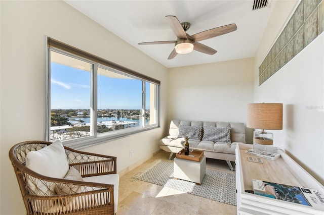 living room with ceiling fan and a water view