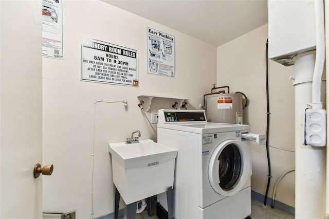 clothes washing area with washer / clothes dryer, electric water heater, and sink