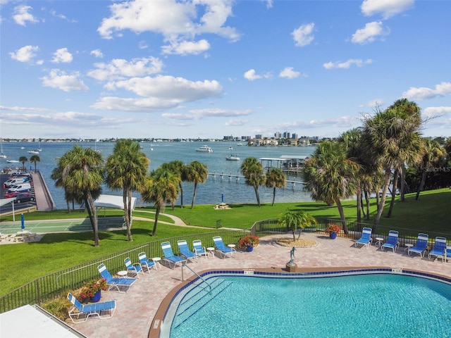 view of pool featuring a lawn, a patio, and a water view