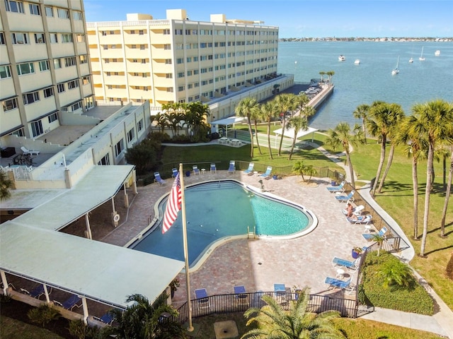 view of swimming pool with a lawn, a water view, and a patio area