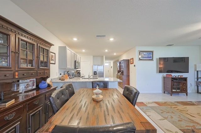 dining area featuring sink and light tile patterned floors