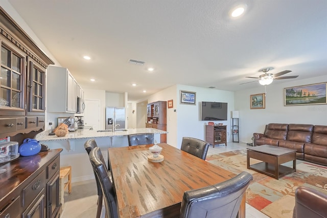 dining space with ceiling fan and light tile patterned flooring