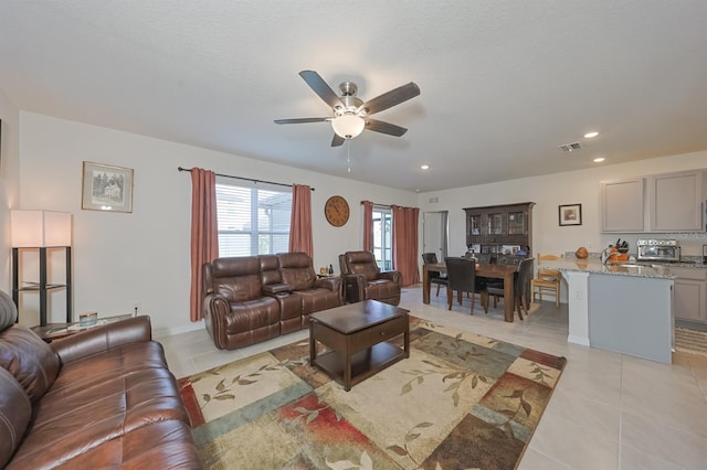 living room with ceiling fan and light tile patterned floors