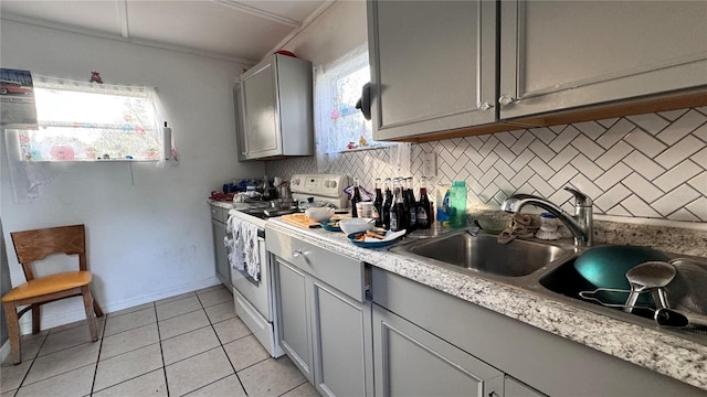 kitchen featuring a sink, light countertops, backsplash, gray cabinets, and white range with electric stovetop