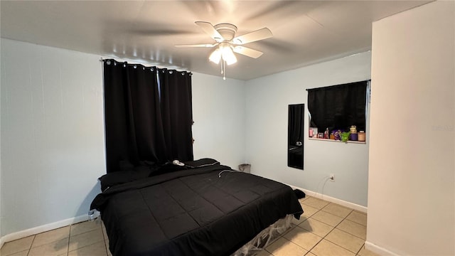 bedroom with light tile patterned floors, ceiling fan, and baseboards