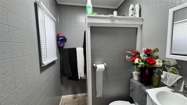 bathroom featuring tile walls, toilet, and tile patterned floors