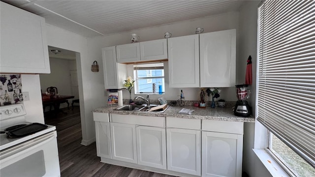 kitchen with light countertops, white range with electric stovetop, white cabinetry, and a sink