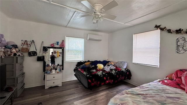 bedroom with a wall unit AC, ceiling fan, baseboards, and dark wood-style flooring