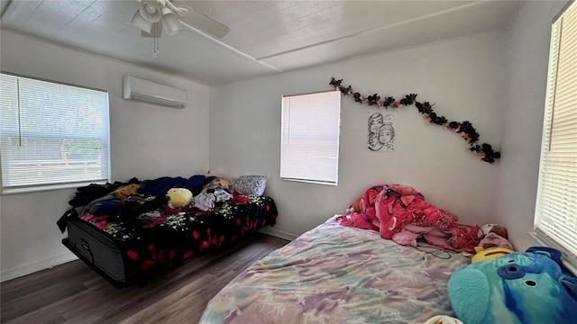 bedroom with ceiling fan, an AC wall unit, wood finished floors, and baseboards