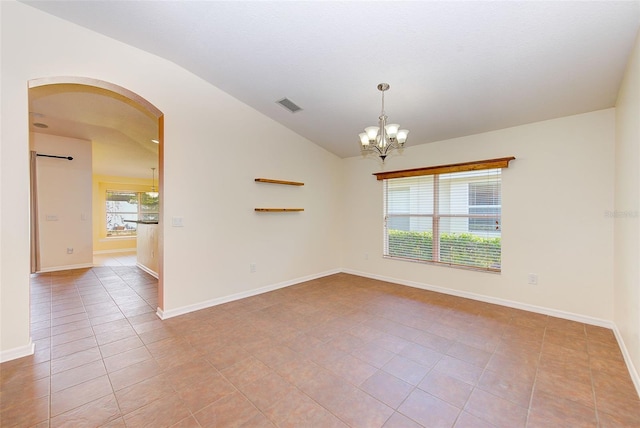 tiled empty room featuring a notable chandelier and vaulted ceiling