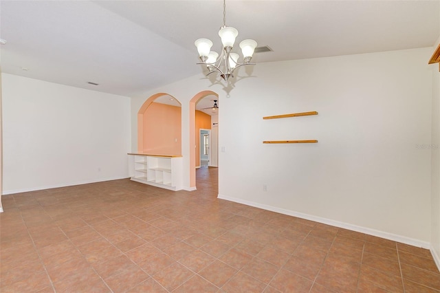 tiled empty room featuring an inviting chandelier