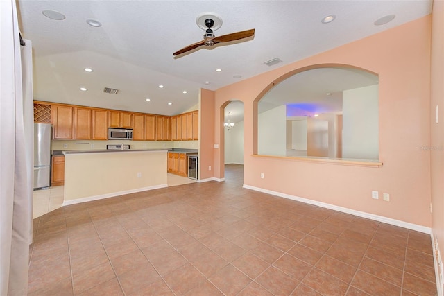 kitchen with ceiling fan, light tile floors, a kitchen island, stainless steel appliances, and beverage cooler