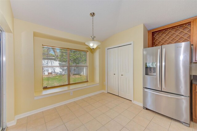 kitchen with light tile flooring, stainless steel refrigerator with ice dispenser, and pendant lighting