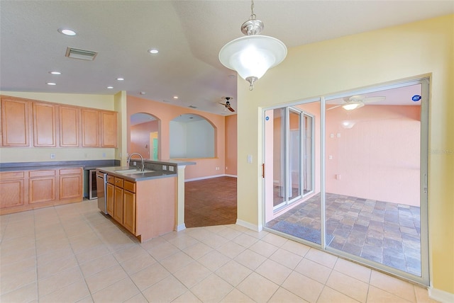 kitchen featuring an island with sink, sink, ceiling fan, decorative light fixtures, and lofted ceiling