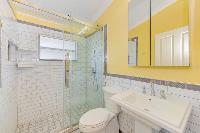 bathroom featuring tile walls, sink, tasteful backsplash, toilet, and a shower with shower door