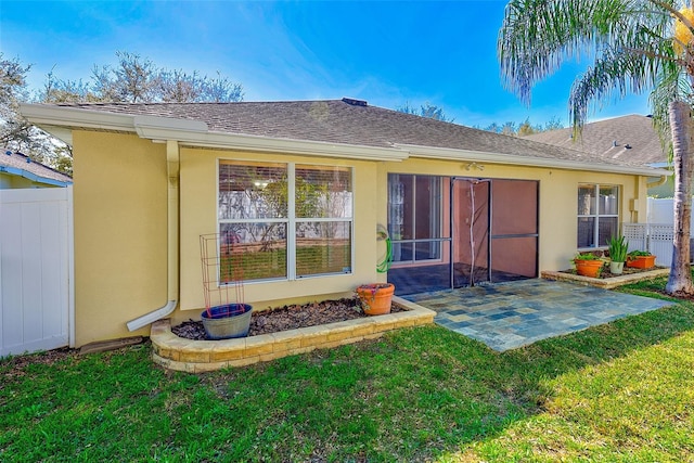 rear view of property featuring a lawn and a patio area