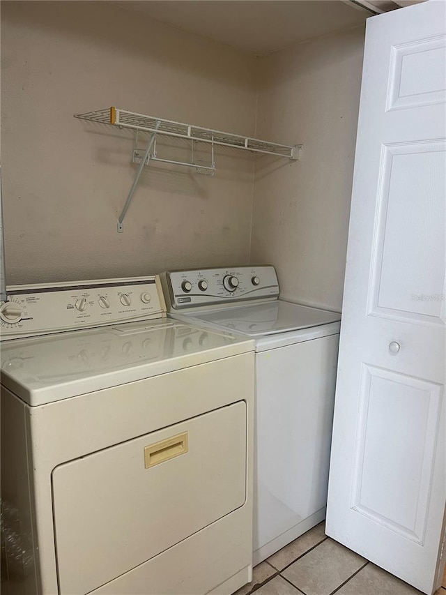 washroom with light tile floors and washing machine and clothes dryer