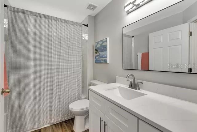 bathroom with vanity, hardwood / wood-style floors, and toilet