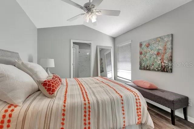 bedroom with dark wood-type flooring, ceiling fan, and vaulted ceiling