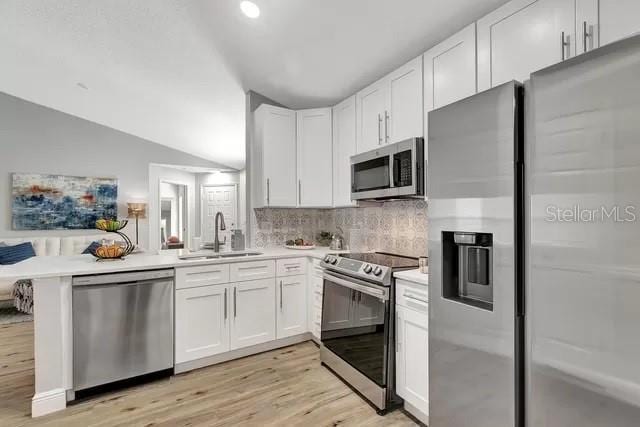 kitchen with light hardwood / wood-style floors, white cabinets, appliances with stainless steel finishes, and sink