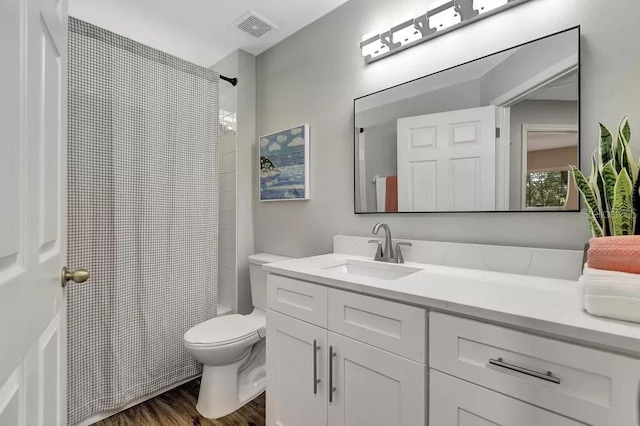 bathroom with toilet, hardwood / wood-style floors, and vanity