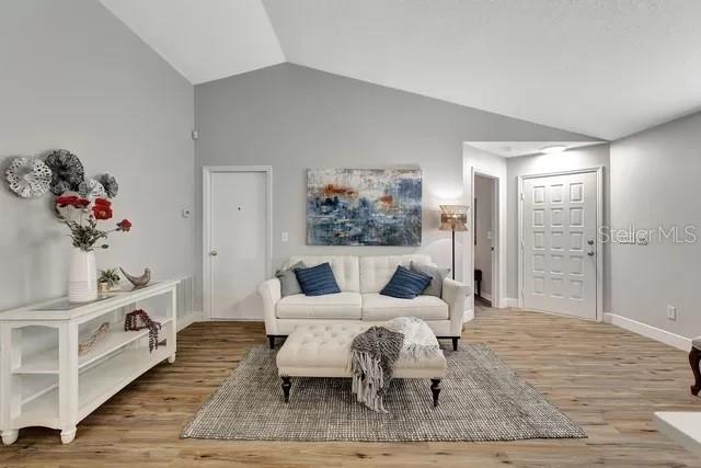 interior space featuring lofted ceiling and light wood-type flooring