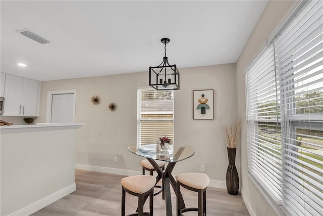 dining area with an inviting chandelier and light hardwood / wood-style floors